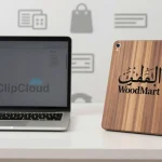 A modern office desk with a sleek laptop, a stylized wooden tablet labeled 'WoodMart' in elegant Arabic calligraphy, and a subtle background of e-commerce icons like shopping bags and payment symbols, all rendered in a clean, professional style