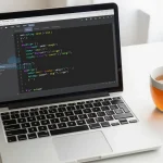 A clean, modern Python programming workspace with a laptop screen displaying readable Python code, a cup of tea, and a notebook with handwritten notes, soft natural lighting, no text or numbers visible on objects